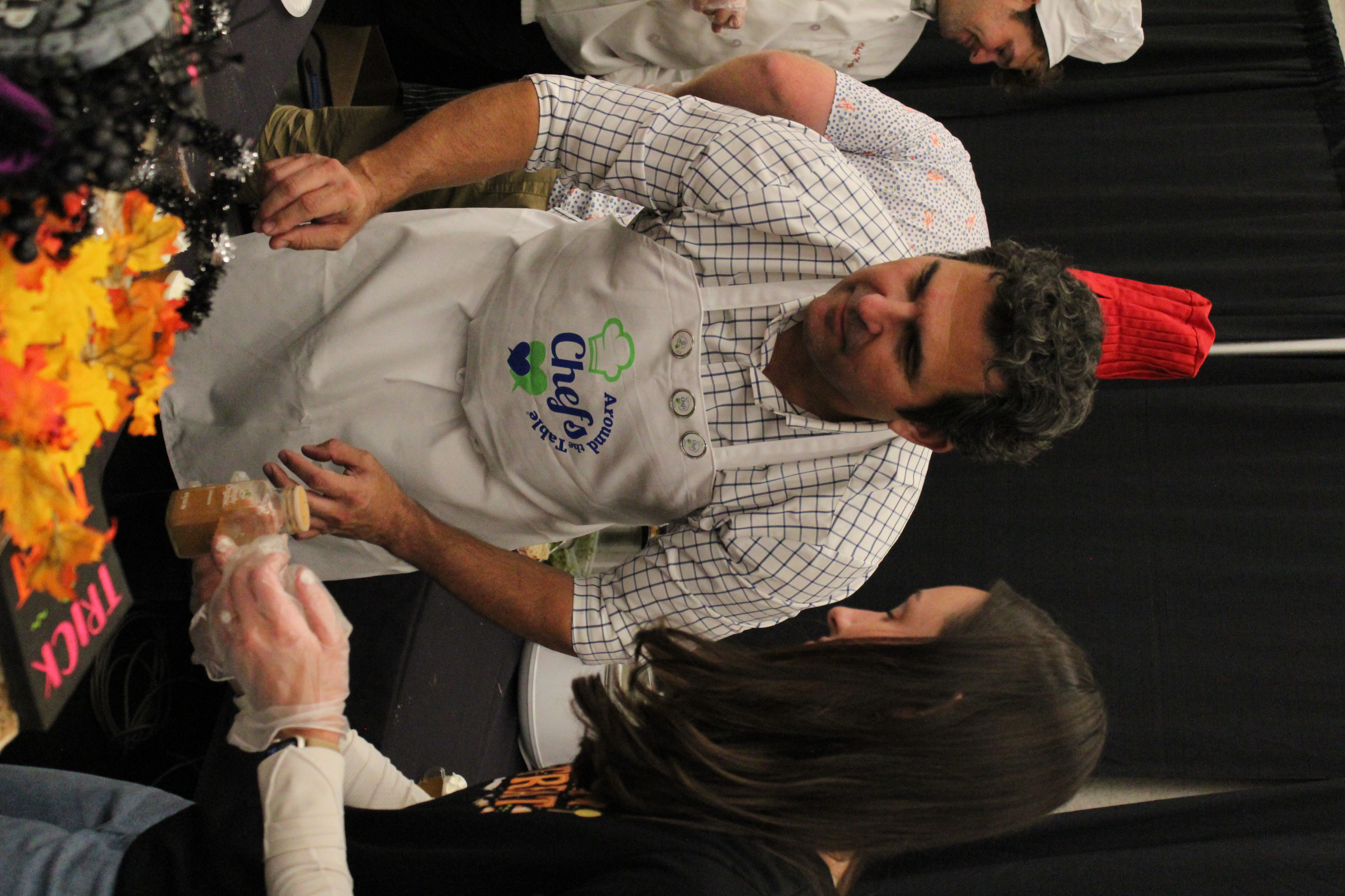 Dr. Nenadovich looking to grab something on a Halloween decorated table.